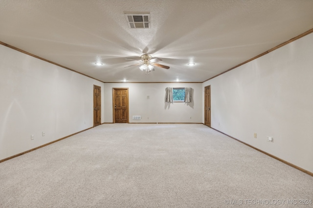 spare room with crown molding, baseboards, visible vents, and a textured ceiling