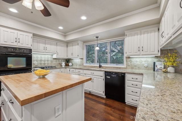 kitchen with black appliances, dark hardwood / wood-style floors, white cabinets, butcher block counters, and pendant lighting