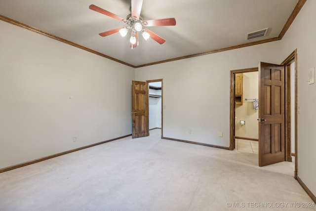 empty room featuring visible vents, light carpet, crown molding, baseboards, and ceiling fan