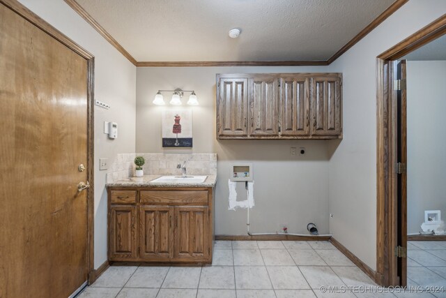 bathroom with a textured ceiling, vanity, crown molding, tile patterned flooring, and backsplash