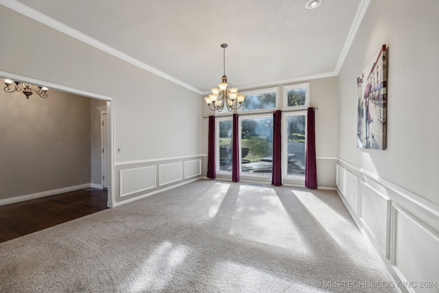 carpeted empty room featuring a notable chandelier, a decorative wall, a wainscoted wall, and ornamental molding