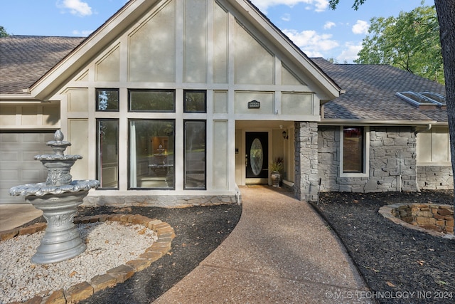 exterior space featuring stone siding and roof with shingles