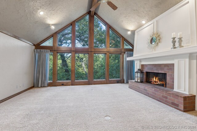 unfurnished living room featuring a fireplace, high vaulted ceiling, and carpet flooring