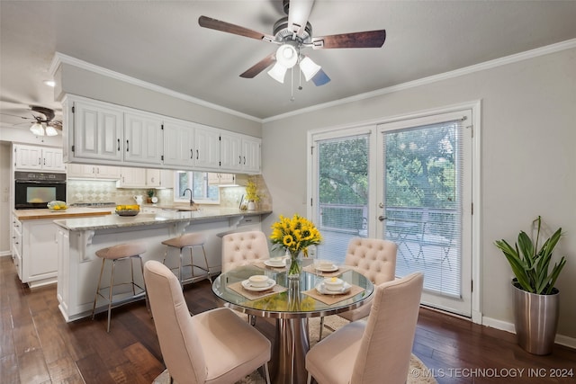 dining space with dark wood-type flooring, ornamental molding, and ceiling fan