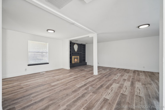 unfurnished living room with a large fireplace and hardwood / wood-style floors