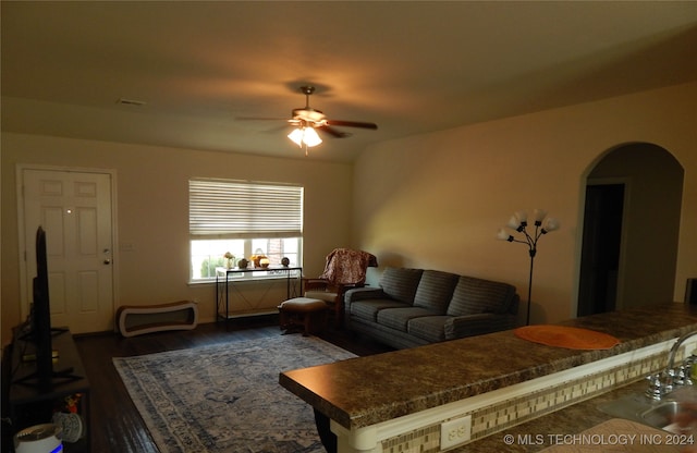 living room featuring ceiling fan, dark wood-type flooring, and sink