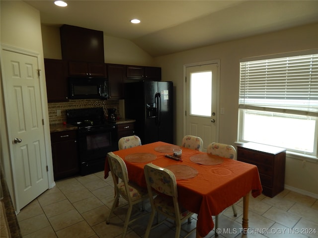 dining room featuring light tile patterned flooring and vaulted ceiling