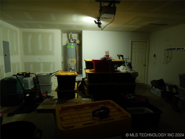 garage featuring gas water heater, a garage door opener, and electric panel