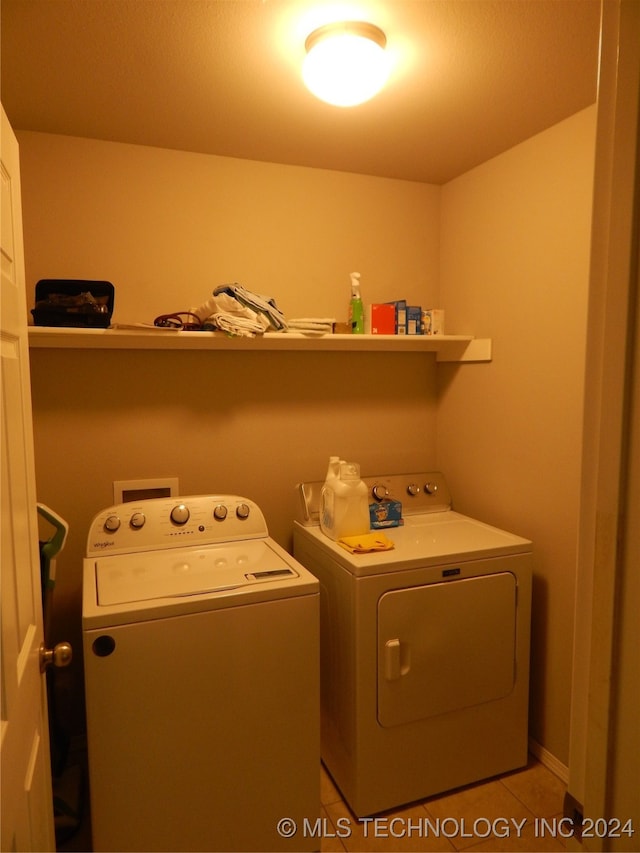 laundry area featuring light tile patterned floors and washing machine and dryer