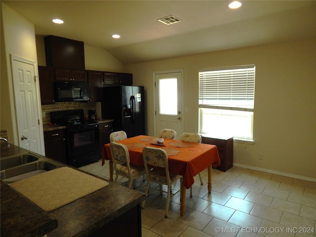 tiled dining area featuring lofted ceiling and sink