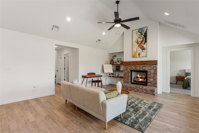 living room with ceiling fan, a fireplace, light wood-type flooring, and lofted ceiling