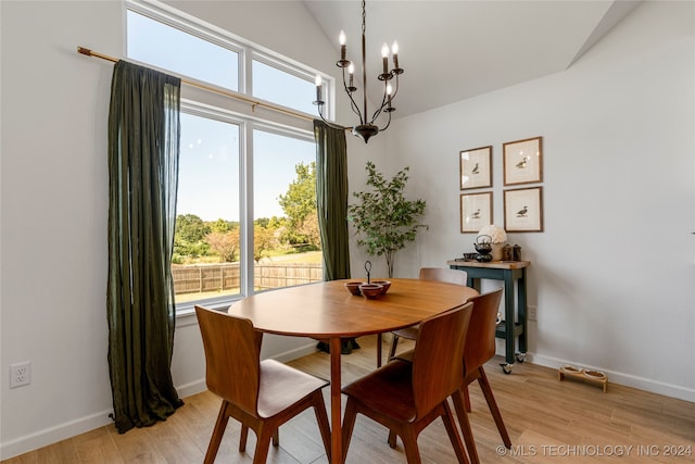 dining area with a notable chandelier, light hardwood / wood-style flooring, lofted ceiling, and a wealth of natural light