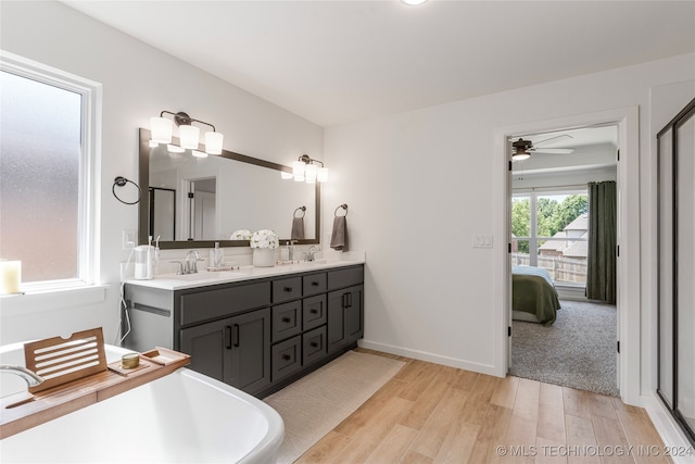 bathroom featuring vanity, ceiling fan, plus walk in shower, and hardwood / wood-style flooring