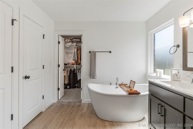 bathroom with vanity, a bathtub, and hardwood / wood-style flooring