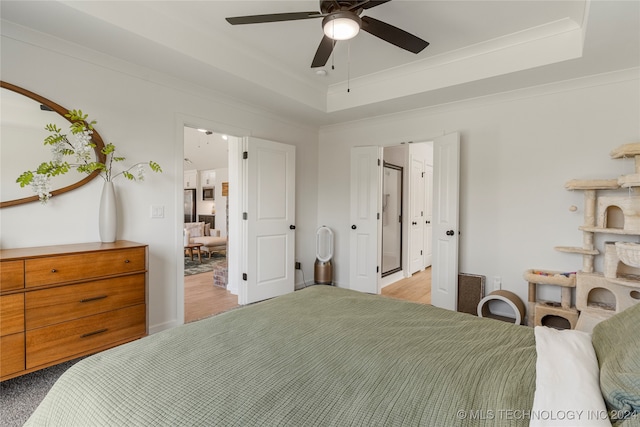 bedroom with ceiling fan, a raised ceiling, and crown molding