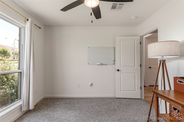 carpeted bedroom with multiple windows and ceiling fan