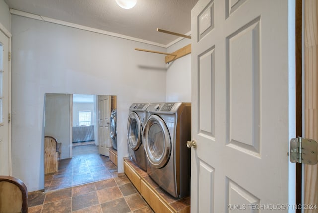 laundry area with a textured ceiling and washing machine and clothes dryer