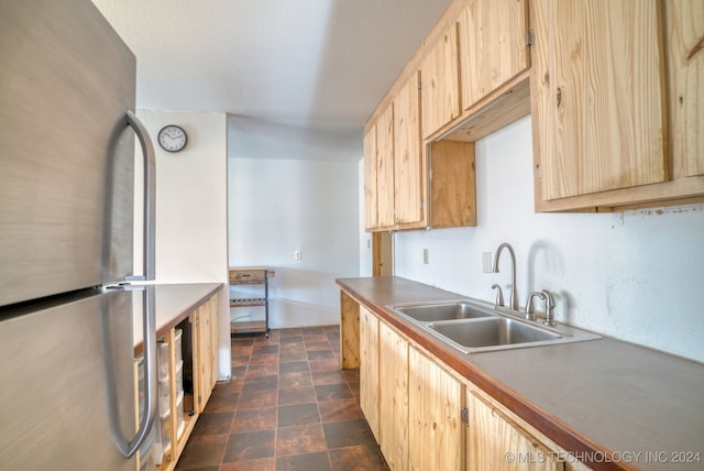 kitchen featuring sink, stainless steel fridge, and light brown cabinets