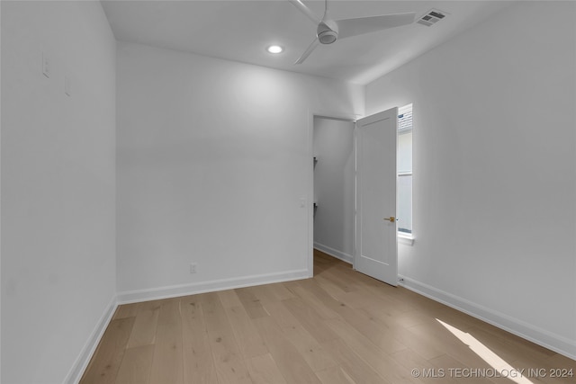 empty room with ceiling fan and light hardwood / wood-style flooring