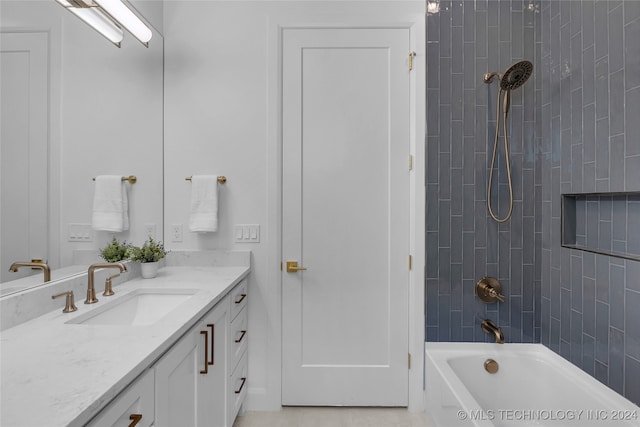 bathroom with tiled shower / bath and vanity