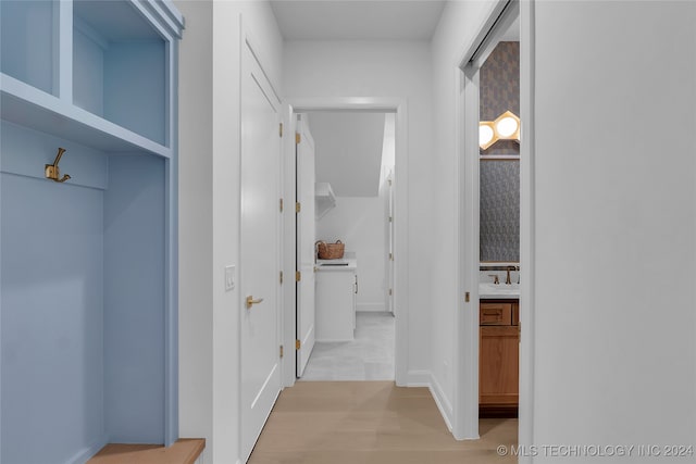 hallway with light hardwood / wood-style flooring and sink