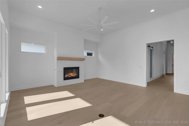 unfurnished living room with hardwood / wood-style floors, ceiling fan, and a fireplace