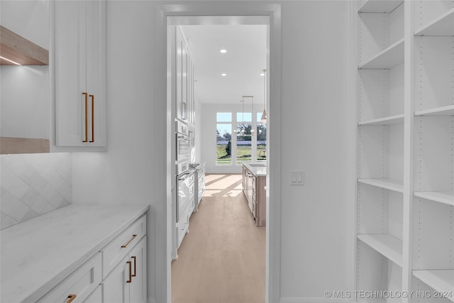 hallway with light wood-type flooring and sink