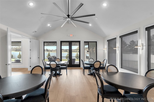 dining area featuring french doors, lofted ceiling, and light hardwood / wood-style flooring