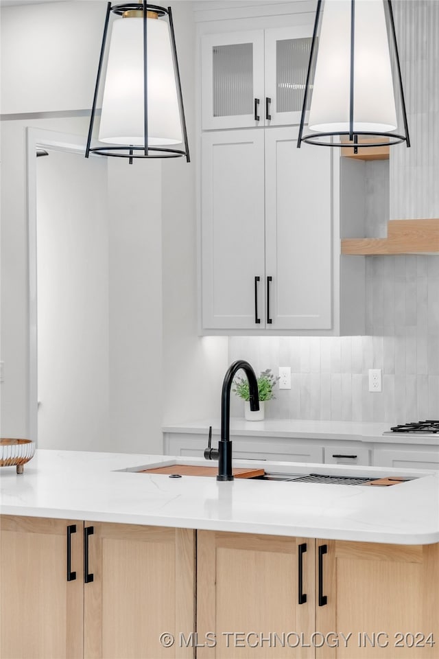 kitchen featuring light brown cabinetry, exhaust hood, white gas stovetop, and white cabinetry