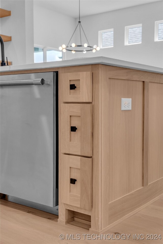 interior details featuring pendant lighting, stainless steel dishwasher, a chandelier, light brown cabinetry, and light wood-type flooring