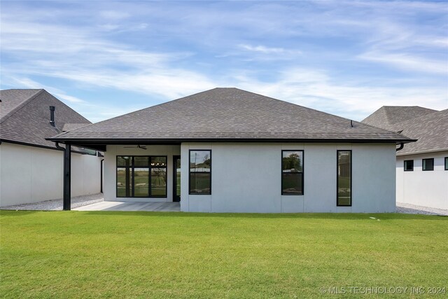 back of property featuring a lawn, ceiling fan, and a patio area