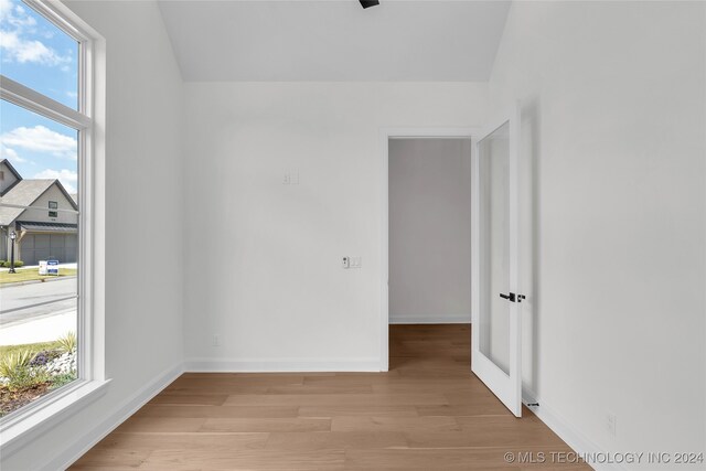 empty room with plenty of natural light and light hardwood / wood-style floors