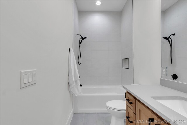 full bathroom with tiled shower / bath, vanity, and toilet