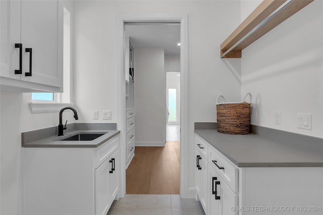 kitchen featuring light wood-type flooring, sink, and white cabinets