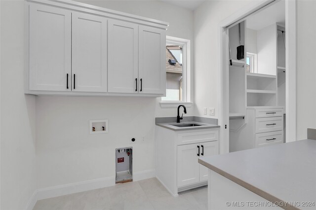 clothes washing area featuring cabinets, washer hookup, sink, electric dryer hookup, and light tile patterned floors