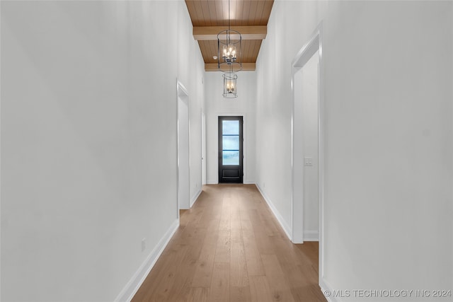 hallway featuring wood ceiling, a chandelier, beam ceiling, and light hardwood / wood-style flooring