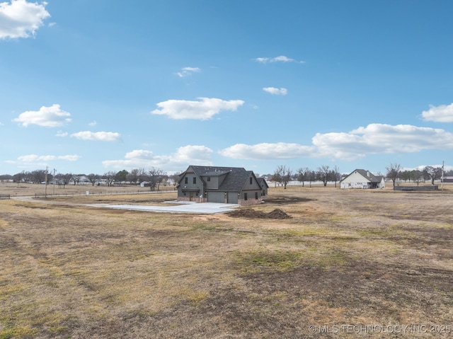 view of yard with a rural view and a garage