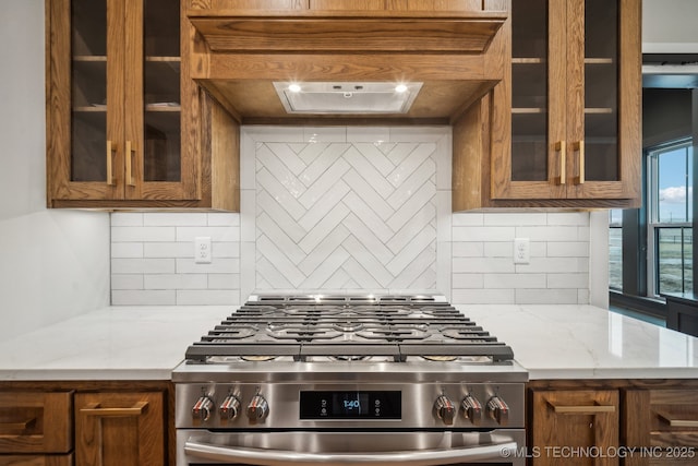 kitchen featuring stainless steel range with gas cooktop, light stone countertops, and decorative backsplash