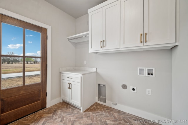 washroom featuring hookup for a washing machine, electric dryer hookup, cabinets, and hookup for a gas dryer