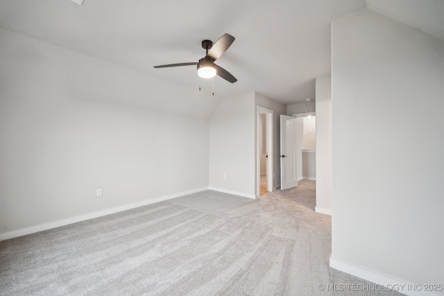 empty room with vaulted ceiling, light colored carpet, and ceiling fan