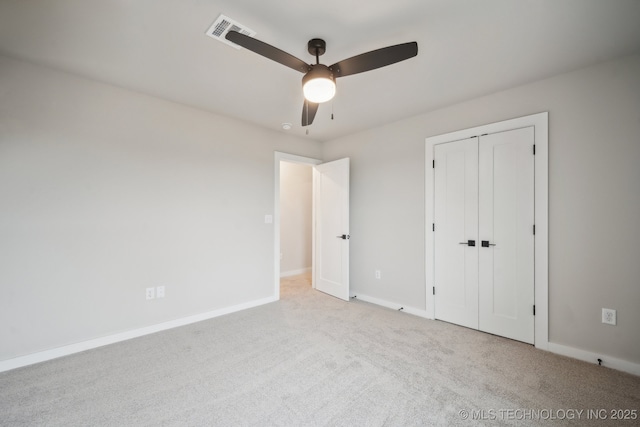 unfurnished bedroom featuring light colored carpet, a closet, and ceiling fan