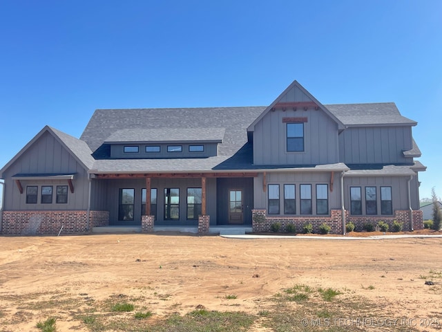 view of front of home with brick siding and board and batten siding