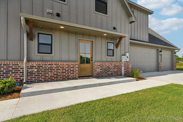 17599 S Harvard Ave, Mounds, OK 74047 - view of front of home featuring board and batten siding, brick siding, driveway, an attached garage, and a shingled roof