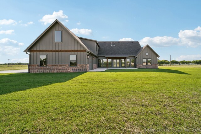 17599 S Harvard Ave, Mounds, OK 74047 - rear view of property featuring board and batten siding, a yard, brick siding, and roof with shingles