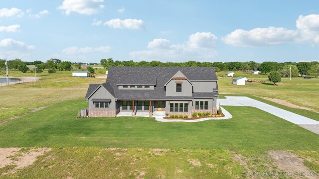 17599 S Harvard Ave, Mounds, OK 74047 - modern farmhouse with a front yard, roof with shingles, a porch, and brick siding