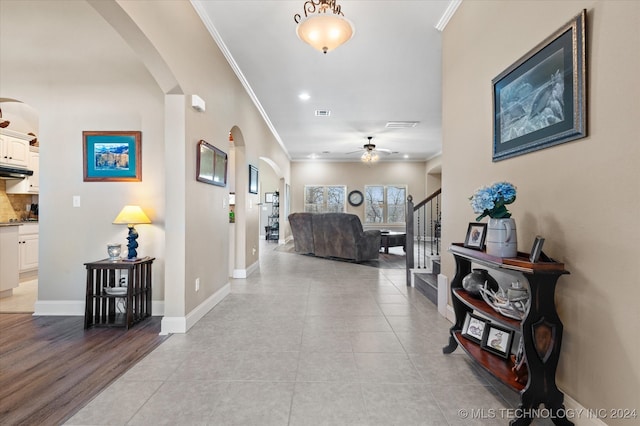 foyer featuring light hardwood / wood-style floors, ceiling fan, and crown molding