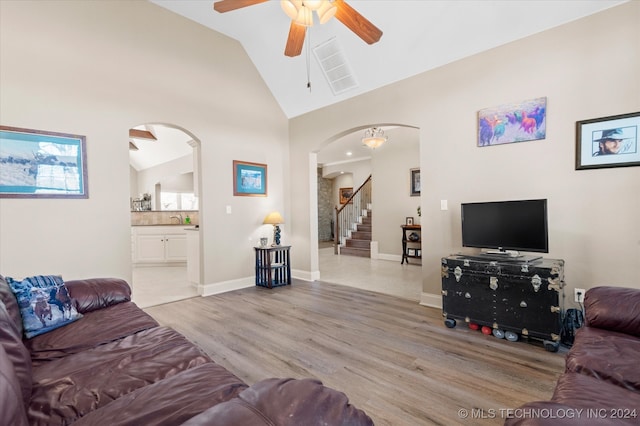 living room with high vaulted ceiling, sink, ceiling fan, and light hardwood / wood-style flooring