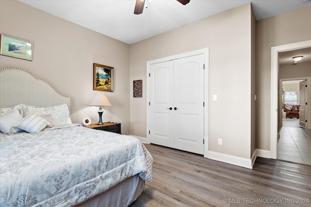 bedroom with ceiling fan, a closet, and hardwood / wood-style floors