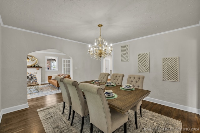 dining area featuring ornamental molding, a notable chandelier, dark wood-type flooring, and a textured ceiling