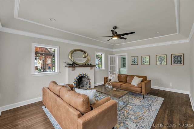 living room featuring ornamental molding, a tray ceiling, ceiling fan, and dark hardwood / wood-style flooring